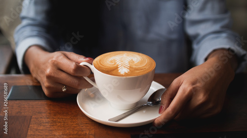 coffee latte art in cafe with woman hand