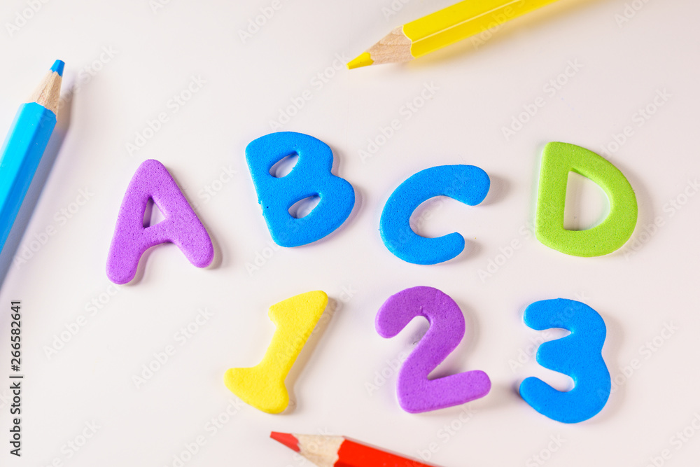 Naklejka premium Alphabet letters and numbers over a kid's school desk. Suitable for back to school activities , The first day of classes, office or end of vacations or Kids concepts.