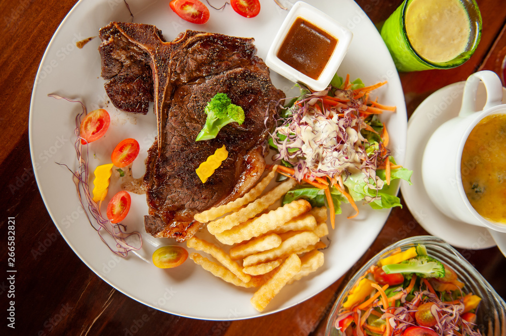 Medium rare Grilled T-Bone Steak with salad.
