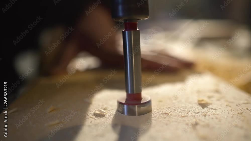 In the woodworkers shop the cnc drill is drilling a letters in to the wooden plank to make a sine, close up footage In the woodworkers shop the cnc drill is drilling a letters in to the wooden plank to make a sine, close up footage