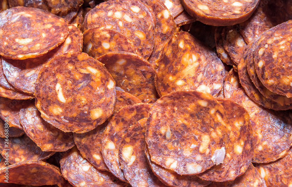 Dried red tasty pepper salami or sausage rings snack food close up background with selective focus view from above Dried red tasty pepper salami or sausage rings snack food close up background with selective focus view from above