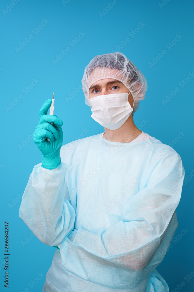 Surgeon in sterile blue uniform, medical gloves and mask Surgeon in sterile blue uniform, medical gloves and mask