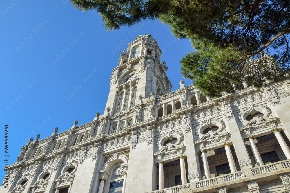Townhall Porto Portugal with blue sky and part of green tree in front