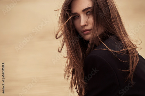 Boho style woman portrait sitting on sand, fashion clothes, sunny outdoor. African safari travel concept