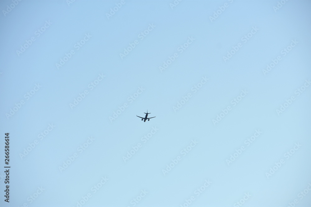 Tiny air plane in blue sky with copy space - minimalist image Tiny air plane in blue sky with copy space - minimalist image