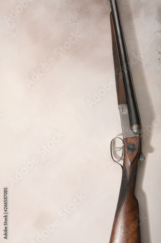Hunting concept with shotgun arranged on light background.