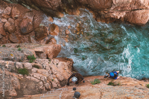 Girls climbing a via ferrata, Sant Feliu de Guixols, Catalunya, Spain (Via ferrata Cala de Molí)