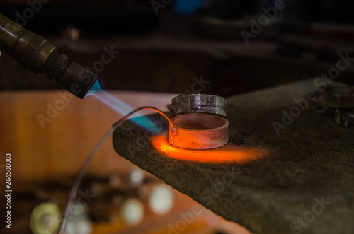 Craft jewelery making with professional tools. Macro shot. A handmade jeweler process, manufacture of jewellery. Melting metal