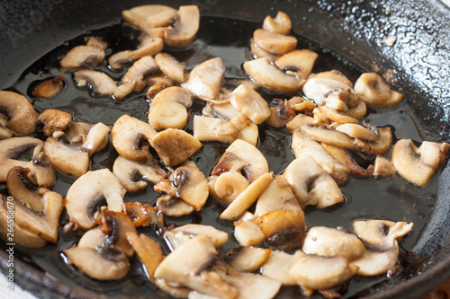 White champignons with mushrooms, fried in a pan, cooking ingredients for soup, salad. Vegetarian healthy protein food for the main course, lifestyle