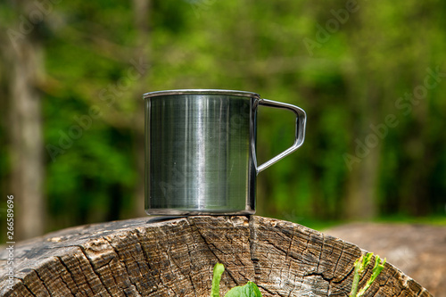 Tourist steel cup in the summer forest outdoors.