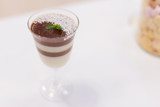Layered chocolate pudding with yogurt decorated with chocolate crumb and in a glass at the bar counter. space for text. Closeup view.