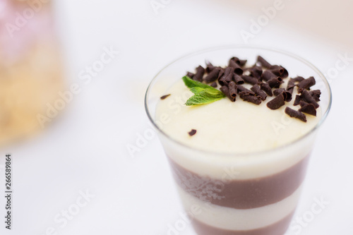 Layered chocolate pudding with yogurt decorated with chocolate crumb and in a glass at the bar counter. space for text. Closeup view.
