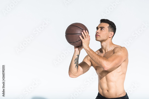 handsome athletic mixed race man playing ball on white background © LIGHTFIELD STUDIOS