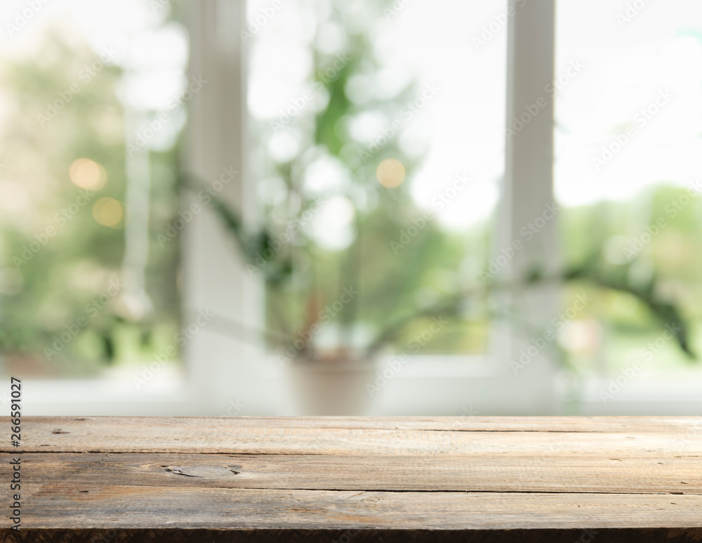 Wood table top on blur of window glass and abstract green from garden with city view in the morning background. For montage product display Wood table top on blur of window glass and abstract green from garden with city view in the morning background. For montage product display