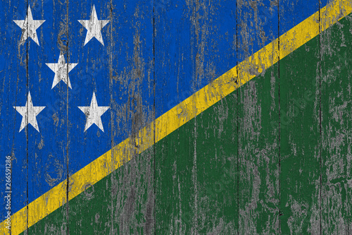 Flag of Solomon Islands painted on worn out wooden texture background.