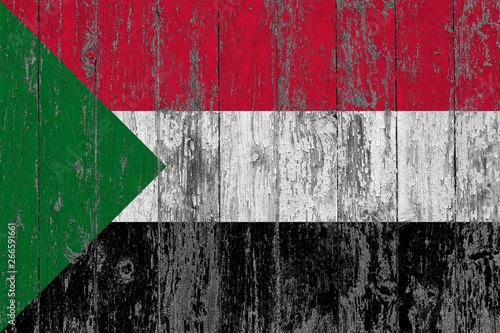 Flag of Sudan painted on worn out wooden texture background.