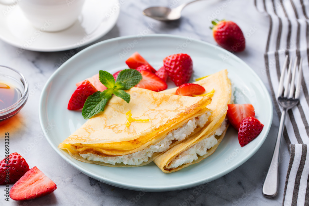 Crepes, thin pancakes with fresh strawberry and ricotta, cream cheese stuffing. Marble background. Crepes, thin pancakes with fresh strawberry and ricotta, cream cheese stuffing. Marble background.