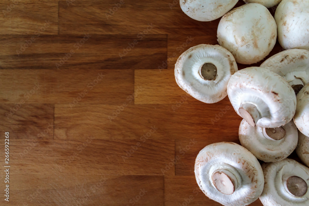 Top view of white mushrooms on wooden table