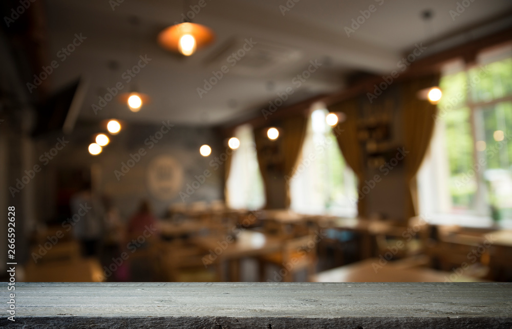Empty wooden table in front of abstract blurred background of coffee shop . can be used for display or montage your products.Mock up for display of product Empty wooden table in front of abstract blurred background of coffee shop . can be used for display or montage your products.Mock up for display of product