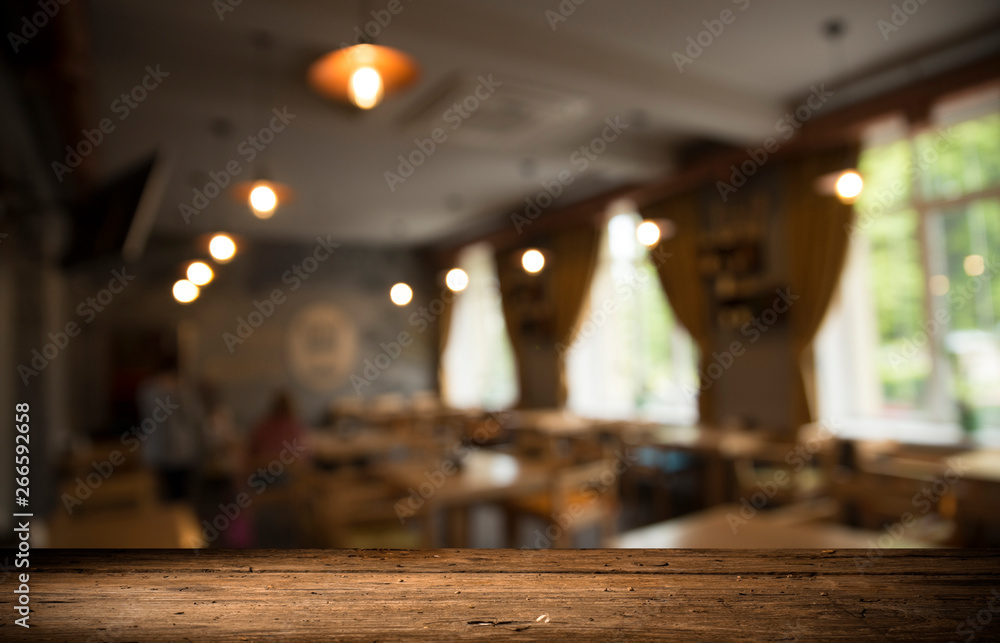 Empty wooden table in front of abstract blurred background of coffee shop . can be used for display or montage your products.Mock up for display of product Empty wooden table in front of abstract blurred background of coffee shop . can be used for display or montage your products.Mock up for display of product