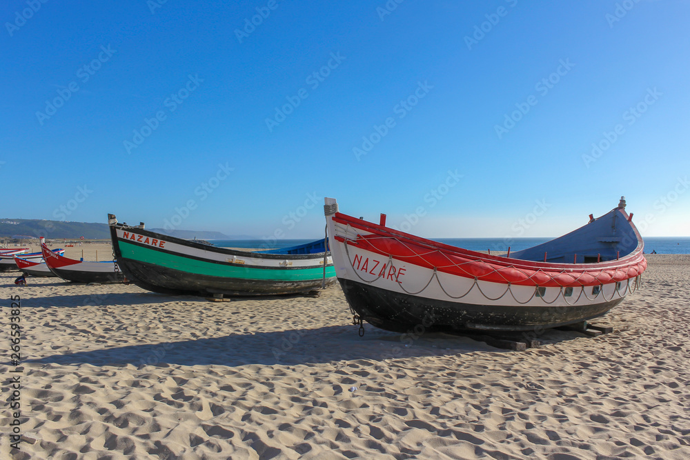 Fototapeta premium Portuguese Traditional colorfull fishing boats on the beach of Nazare, Portugal