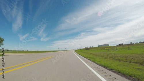 POV. Point of view countryside in the spring. View of beautiful open green areas and a bluebonnet patchs beside the road.