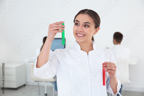 Portrait of medical student with test tubes in modern scientific laboratory