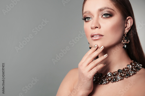 Beautiful woman with stylish jewelry on grey background  space for text