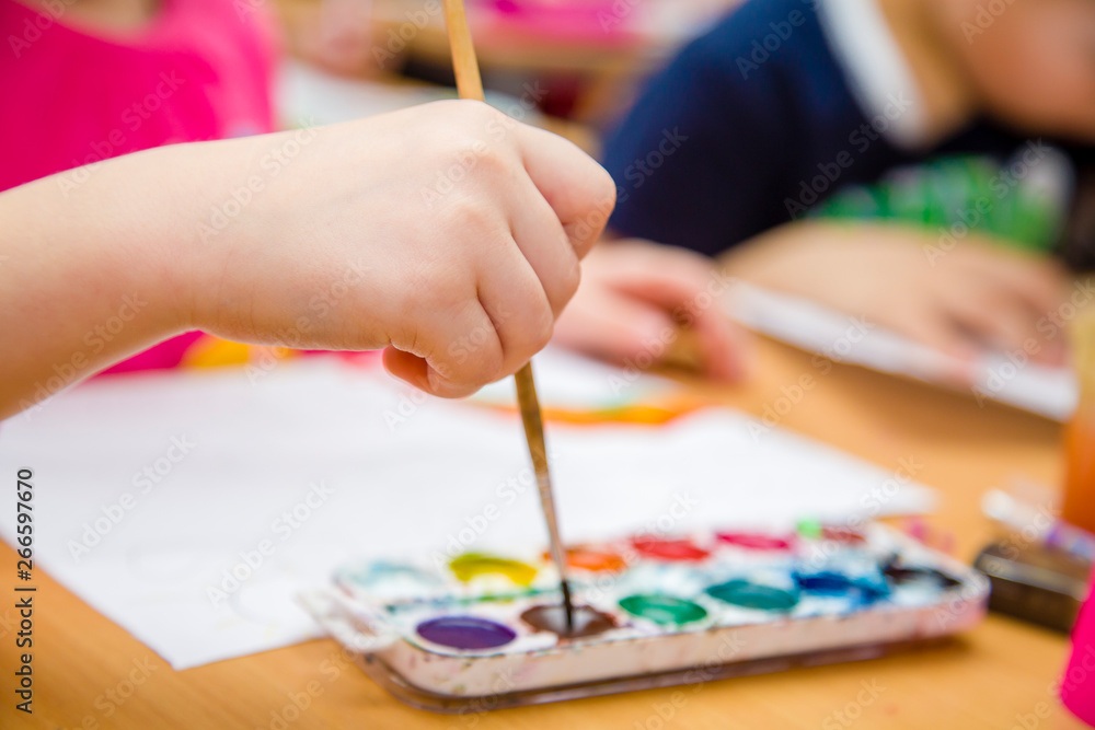 Naklejka premium kid paints in watercolor at school
