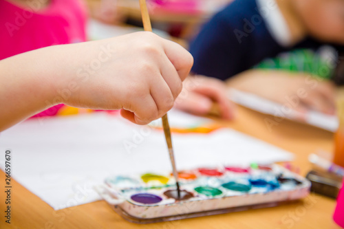 kid paints in watercolor at school