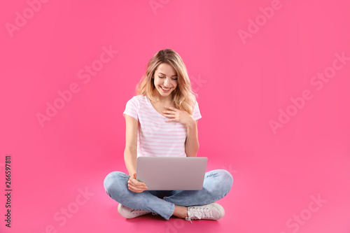 Woman using laptop for video chat on color background