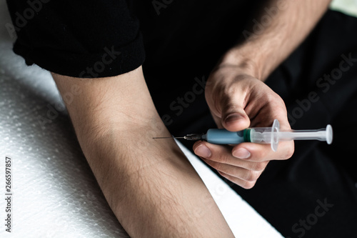Drug addict male doing himself an injection. Drug Abuse. self-medication.