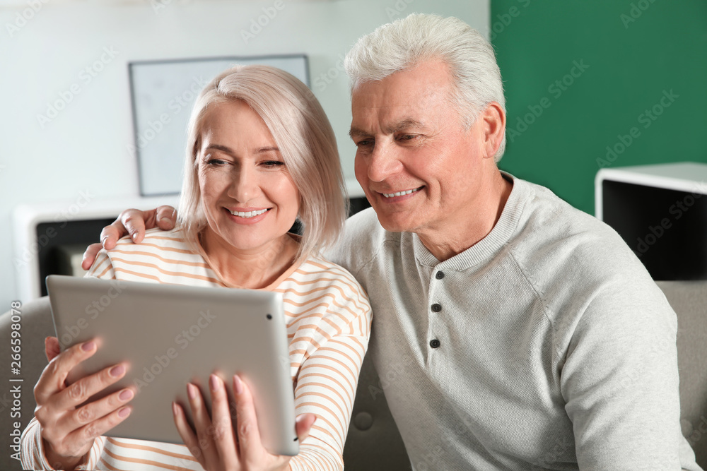 Mature couple using video chat on tablet at home Mature couple using video chat on tablet at home