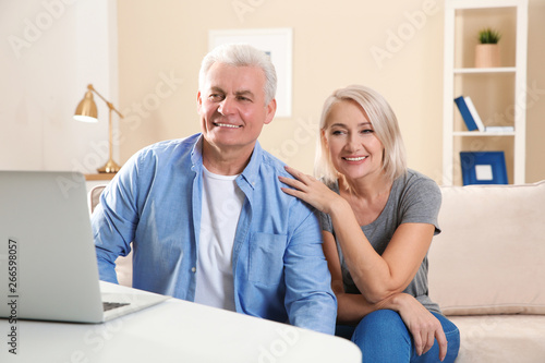 Mature couple using video chat on laptop at home