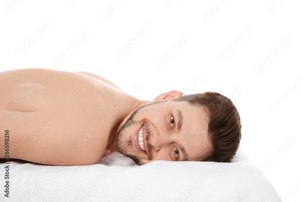 Handsome man relaxing on massage table against white background. Spa service Handsome man relaxing on massage table against white background. Spa service