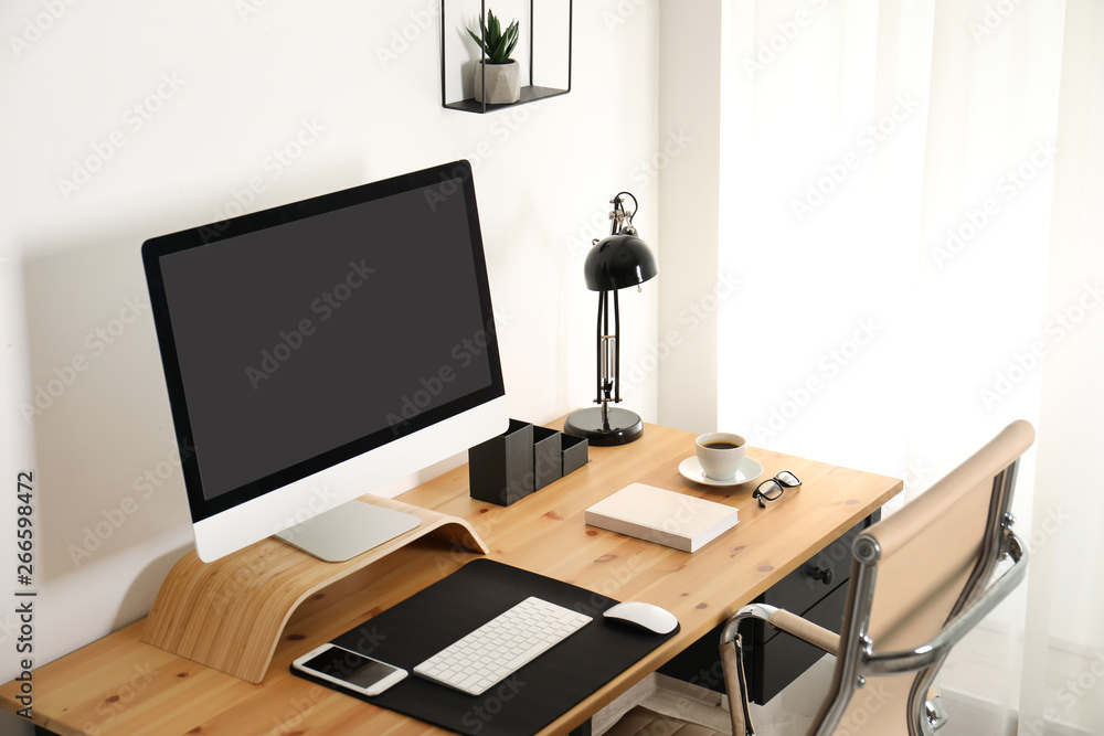 Stylish workplace interior with modern computer on table. Mockup for design