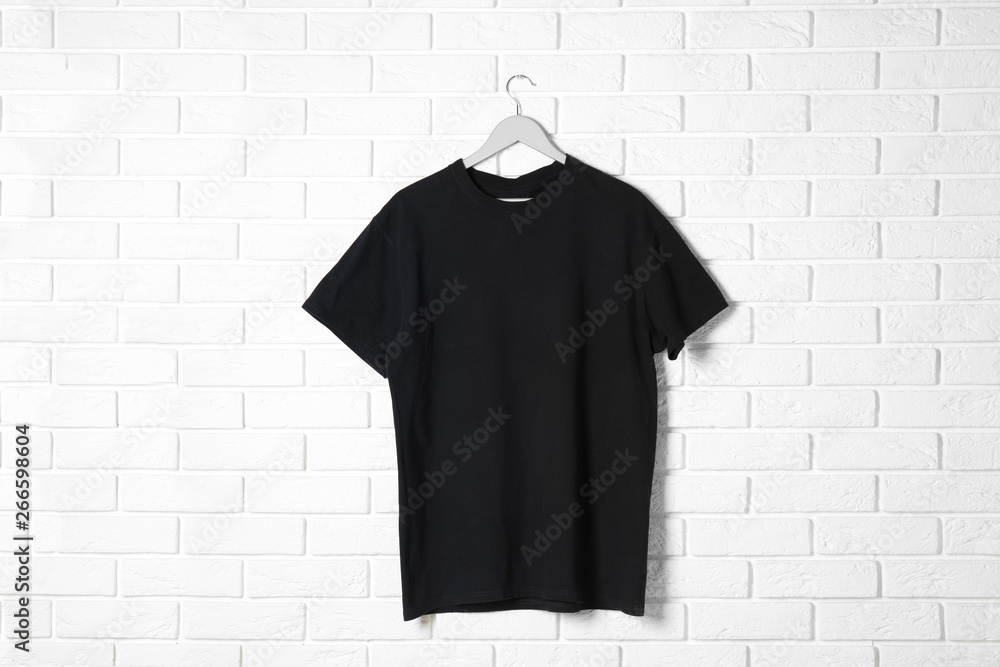 Hanger with black t-shirt against brick wall. Mockup for design Hanger with black t-shirt against brick wall. Mockup for design