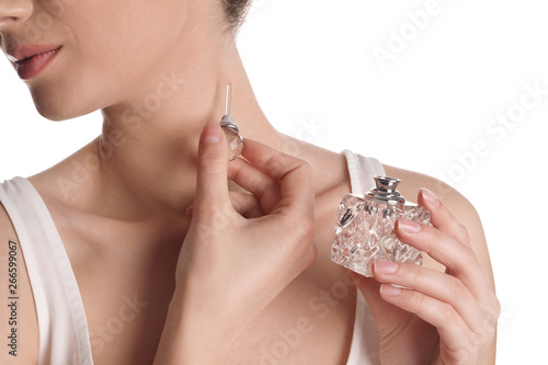 Young woman applying perfume on white background, closeup