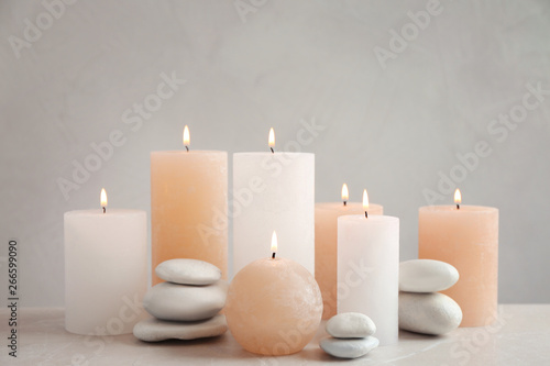 Beautiful composition with candles on table against grey background