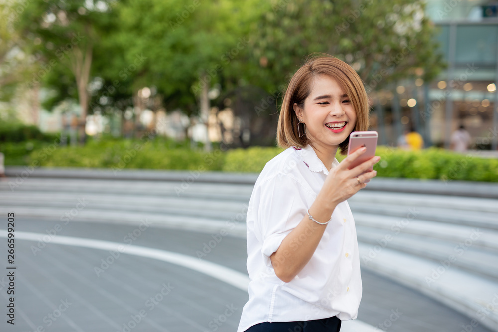 Young beautiful Asian lady celebrate with smart phone in the street in a sunny summer day, success happy pose, internet technology. Young beautiful Asian lady celebrate with smart phone in the street in a sunny summer day, success happy pose, internet technology.