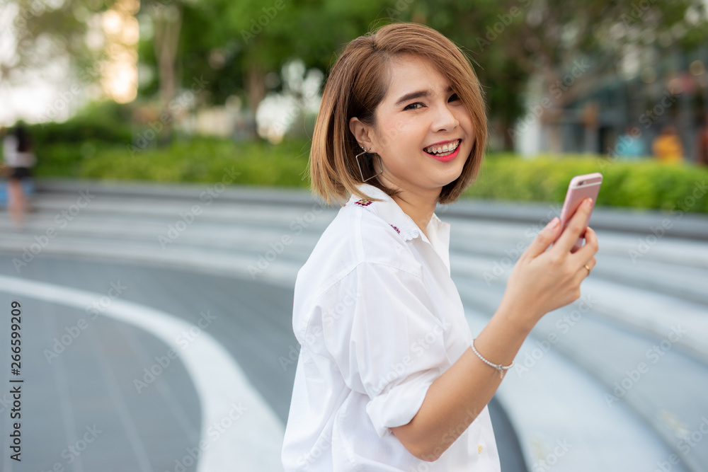 Young beautiful Asian lady celebrate with smart phone in the street in a sunny summer day, success happy pose, internet technology. Young beautiful Asian lady celebrate with smart phone in the street in a sunny summer day, success happy pose, internet technology.