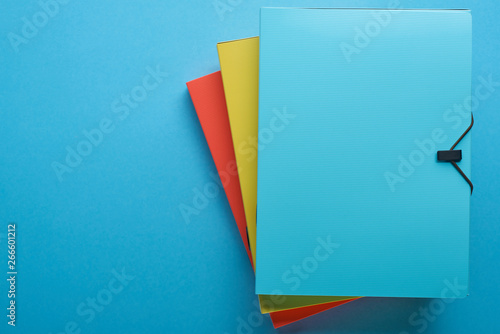 top view of colorful paper binders isolated on blue with copy space photo