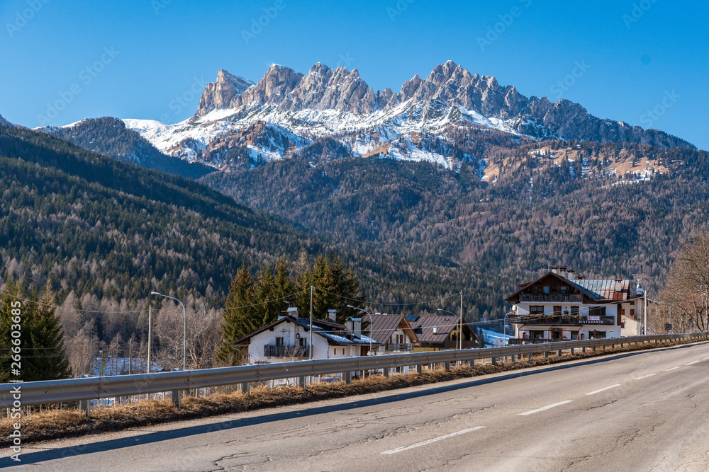 Little village near the road in Dolomites, Italy with mountains in the background