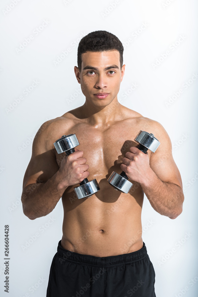 athletic mixed race man holding dumbbells and looking at camera on white athletic mixed race man holding dumbbells and looking at camera on white
