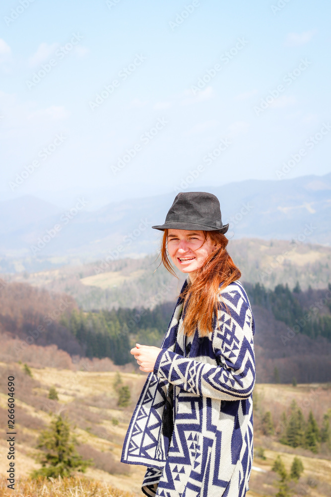 Rudy girl in the mountains in a poncho. Carpathian Mountains. Traveling tours Rudy girl in the mountains in a poncho. Carpathian Mountains. Traveling tours