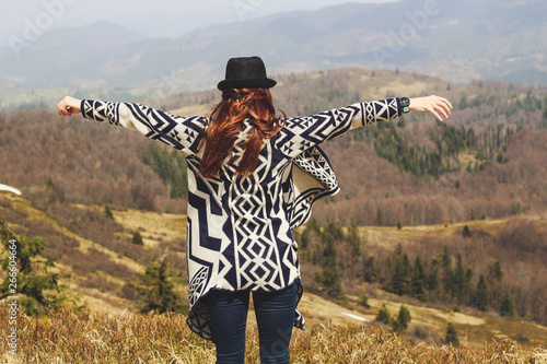 Rudy girl in the mountains in a poncho. Carpathian Mountains. Traveling tours