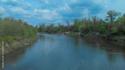 Sunny summer landscape with river.Green hills,fields and meadows.River Medvedica in Volgograd region,Russia.Sunrise.Quiet morning.Calm.Warm sunlight.Cloudless clear blue sky. 