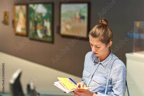 visitor looking pictures in art gallery near pictures photo