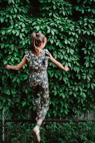 Girl balancing on metal Fence photo