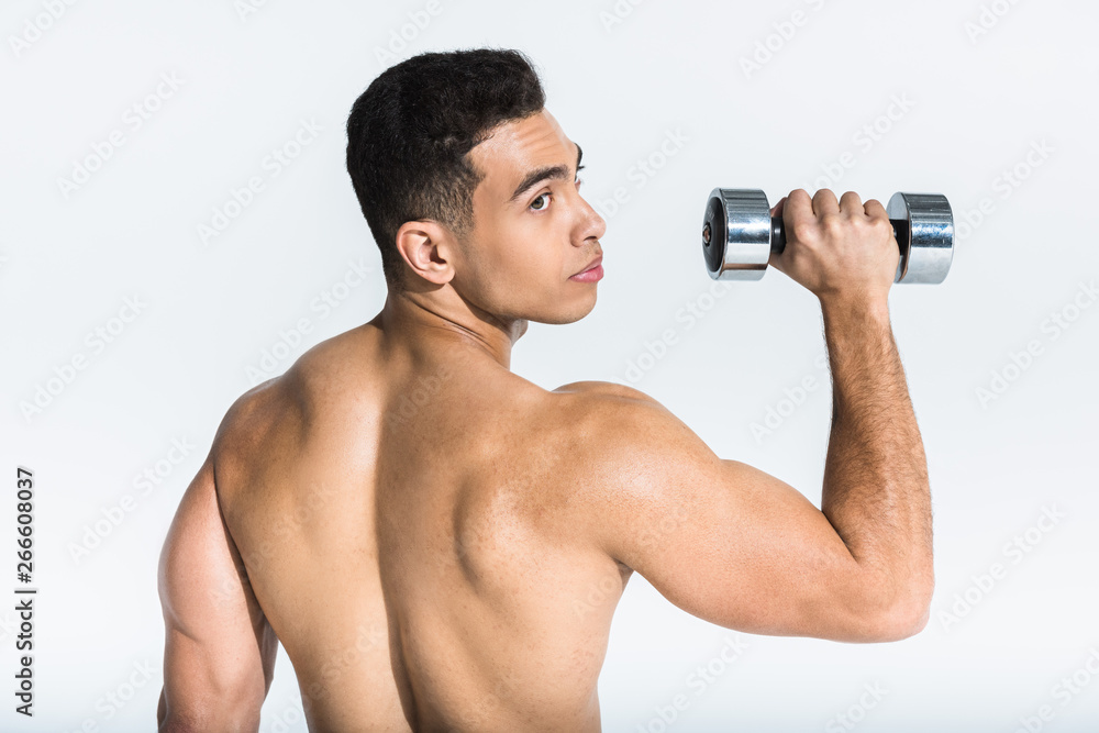 handsome mixed race man with muscular torso holding dumbbell on white